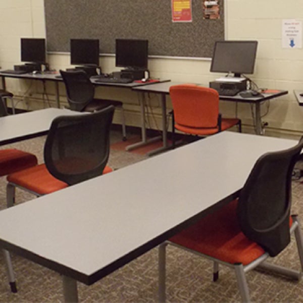 Desks and chairs with computers on some